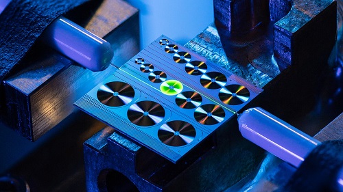 An erbium-doped waveguide amplifier on a photonic integrated chip in 1X1 cm<sup>2</sup> size, with green emission from excited erbium ions. Courtesy of EPFL Laboratory of Photonics and Quantum Measurements (LPQM)/Niels Ackermann.