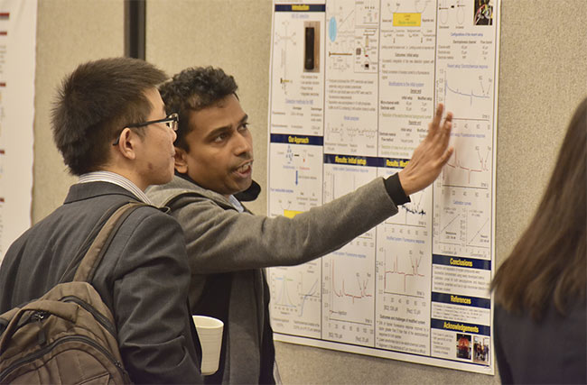 A researcher interacts with an attendee during a poster session at a past SciX conference. Courtesy of FACSS.