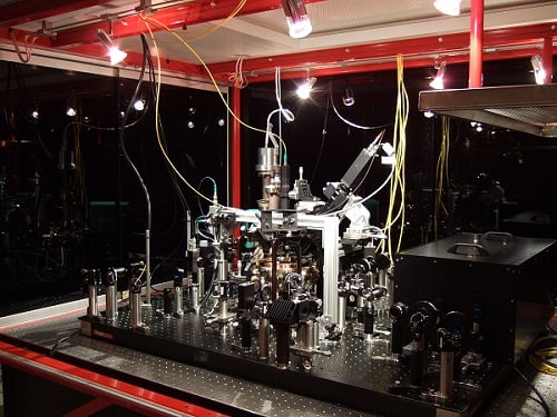 Experimental setup with vacuum chamber on an optical table. Courtesy of MPQ.