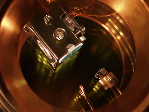 Installation eines optischen Resonators im Vakuum.  Zwischen den konisch geformten Spiegeln im Inneren des Halters ist ein einzelnes Rubidiumatom gefangen.  Mit freundlicher Genehmigung von MPQ.