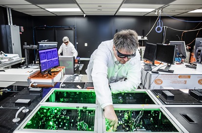 TAU Systems CEO and founder Bjorn Manuel Hegelich aligns laser beams in a laser system at TAU's facility in Austin, Texas. The company aims to open access to particle accelerators by significantly cutting the size of their operation, as well as their cost, and enhancing their sustainable footprint. Courtesy of TAU Systems.