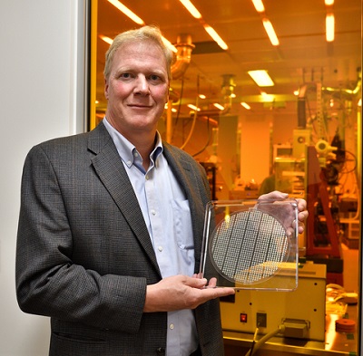 UMass Amherst professor James Watkins displays an example of the advanced optical components that Myrias Optical is capable of producing. Courtesy of Thom Kendall, University of Massachusetts.