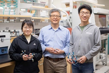 From left: Researcher Xiuyao Lang, professor Kyeongjae Cho, and researcher Yaoqiao Hu found that quantum computing qubits made from transition metal dichalcogenides (TMDs), a family of 2D materials, can surmount the challenges of using synthetic diamonds for qubits. The researchers are holding atomic structure models of solids, with the white sticks representing the bonding between atoms, and the blue, red, and gray balls representing different atoms in solid structures. Courtesy of the University of Texas at Dallas.
