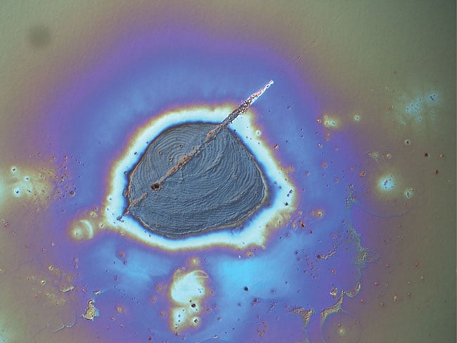 Figure 2. Example of laser-induced damage captured using a differential interference contrast microscope. Courtesy of Edmund Optics.