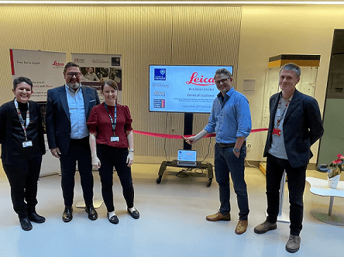 The ribbon cutting ceremony for the Center of Excellence. From left: biochemistry department head Prof Francis Barr, micron bioimaging lead lothar S., micron facility manager Deirdre Kavanaugh, senior VP of global commercial operations at Leica Darin Stell, and micron assistant facility manager Niloufer Irani. Courtesy of Leica Microsystems.