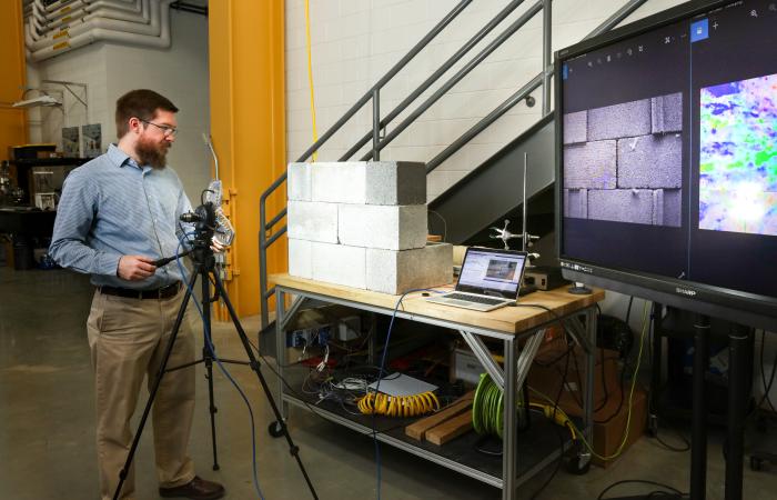 Researcher Philip Boudreaux uses background-oriented schlieren photography to test air leakage through a concrete wall. Courtesy of the Oak Ridge National Laboratory.