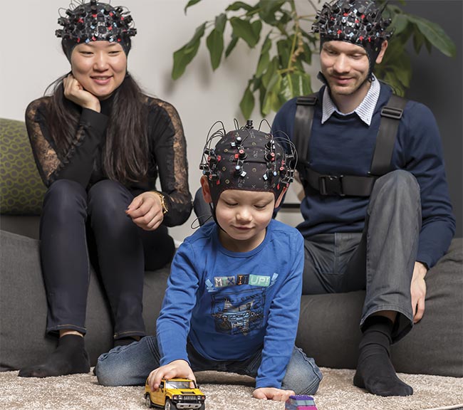 A family wears a commercial, wearable, multichannel, and multiwavelength functional near-infrared spectroscopy (fNIRS) system. Courtesy of NIRx.