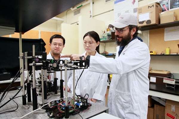 (From left) Professor Jinyang Liang, researcher Miao Liu, and professor Fiorenzo Vetrone in front of the SWIR-PLIMASC device. Courtesy of INRS. 