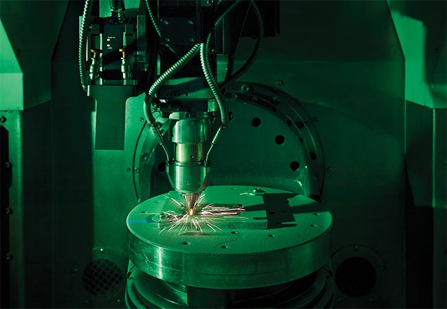 Figure 3. The extreme high-speed laser material deposition (EHLA) method has been transferred into a modified 5-axis computer numerical control system in which the nozzle moves (above). Courtesy of Fraunhofer ILT.