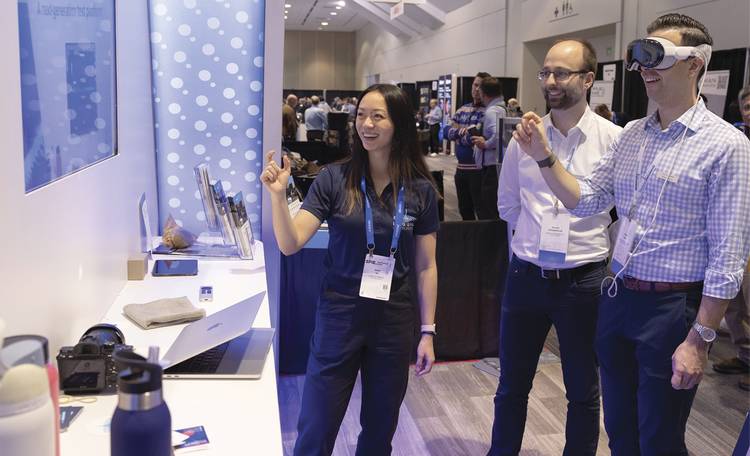 (From left) Nandi Wu of Liquid Instruments explains the functionality of AR/VR technology as Michael Schlagmüller and Thomas Hayes of Swabian Instruments demonstrate its use at last year’s SPIE BiOS Expo. Courtesy of SPIE.