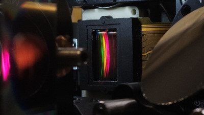 Researchers developed a new type of spectral shaper that can shape the spectrum of 10,000 lines of light from a laser frequency comb. The image shows the spatial light modulator they used with a 2D spectrum on the surface. Courtesy of Optica.