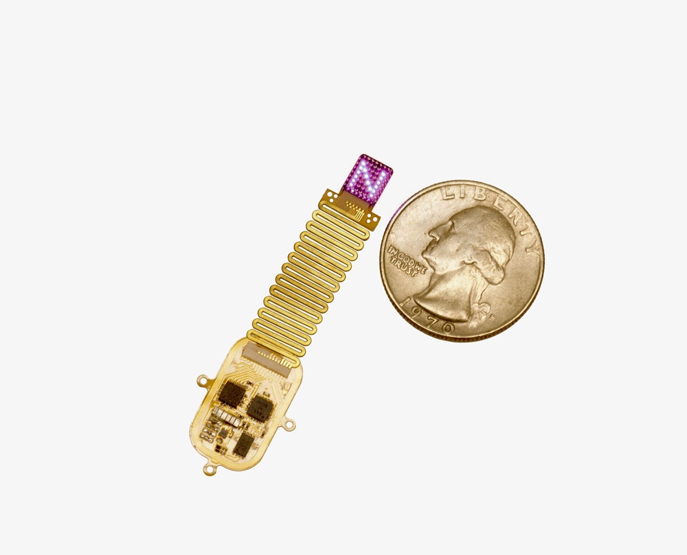 The thin, flexible, wireless device sits next to a quarter for scale. The device emits complex patterns of light to transmit information directly to the brain. Courtesy of Northwestern University/Mingzxheng Wu.