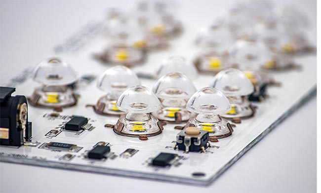 Figure 1. Surface mount optics (SMOs) are aligned onto printed circuit boards (PCBs) using pick-and-place equipment. This assembly step is one of many shared similarities that SMOs share with surface mount technology (SMT) components — their electronics counterparts. Courtesy of LumenFlow.