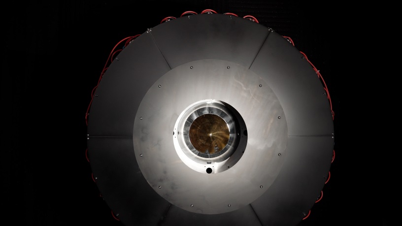 In the optical power beaming receiver designed for PRAD, the laser enters the center aperture, strikes a parabolic mirror, and reflects onto dozens of photovoltaic cells arranged around the inside of the device which convert the energy back to usable power. Courtesy of DARPA.