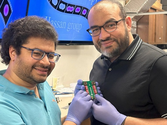 Mohammed Hassan (right), associate professor of physics and optical sciences, and Mohamed Sennary, a graduate student studying optics and physics, holding the commercial transistor they used to develop a petahertz-speed transistor. Courtesy of the University of Arizona.