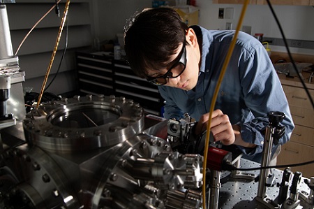 Dongchel Shin, a PhD candidate at MIT and lead author of a paper demonstrating laser cooling of a centimeter-long torsional oscillator, works on an optical setup. Courtesy of MIT/Tony Pulsone.