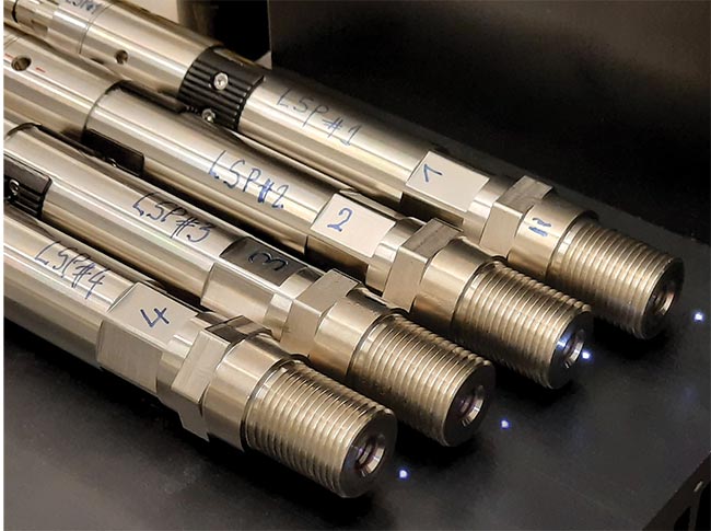 Figure 2. A set of four laser spark plugs during assembling and performance tests. The small sparks are laser plasmas, created due to air breakdown. Courtesy of Fraunhofer IOF and INFLPR, Romania.