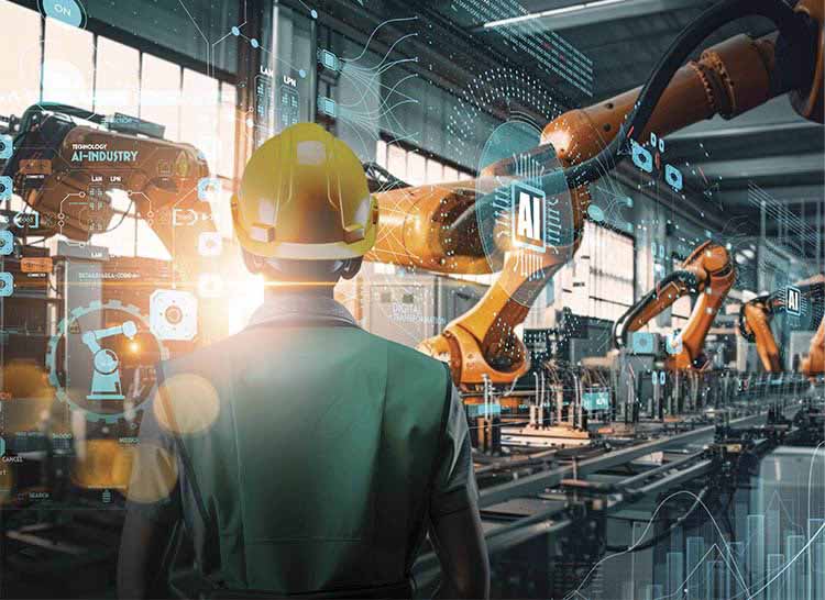 An industrial engineer works with AI automatic robotic arms in an intelligent factory. Courtesy of iStock.com/greenbutterfly.
